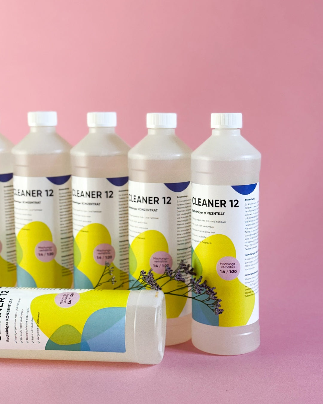 Detailansicht von sechs 1 Liter Flaschen Cleaner 12 Badreiniger Konzentrat mit Fokus auf das Etikett.