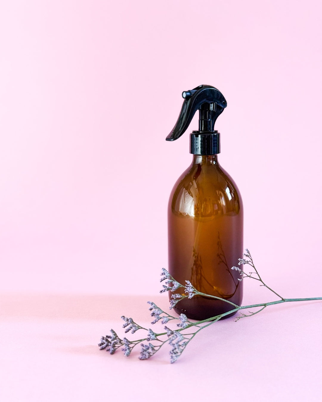 Braune 500ml Glasflasche mit schwarzem Sprühkopf und dekorativer Blume.