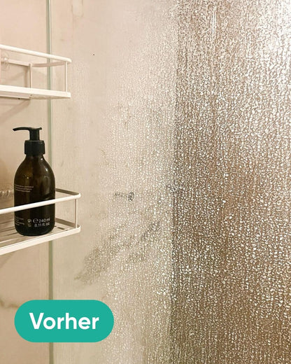 Nahaufnahme einer stark verkalkten Glas-Duschtrennwand mit Wasserflecken vor dem Putzen.