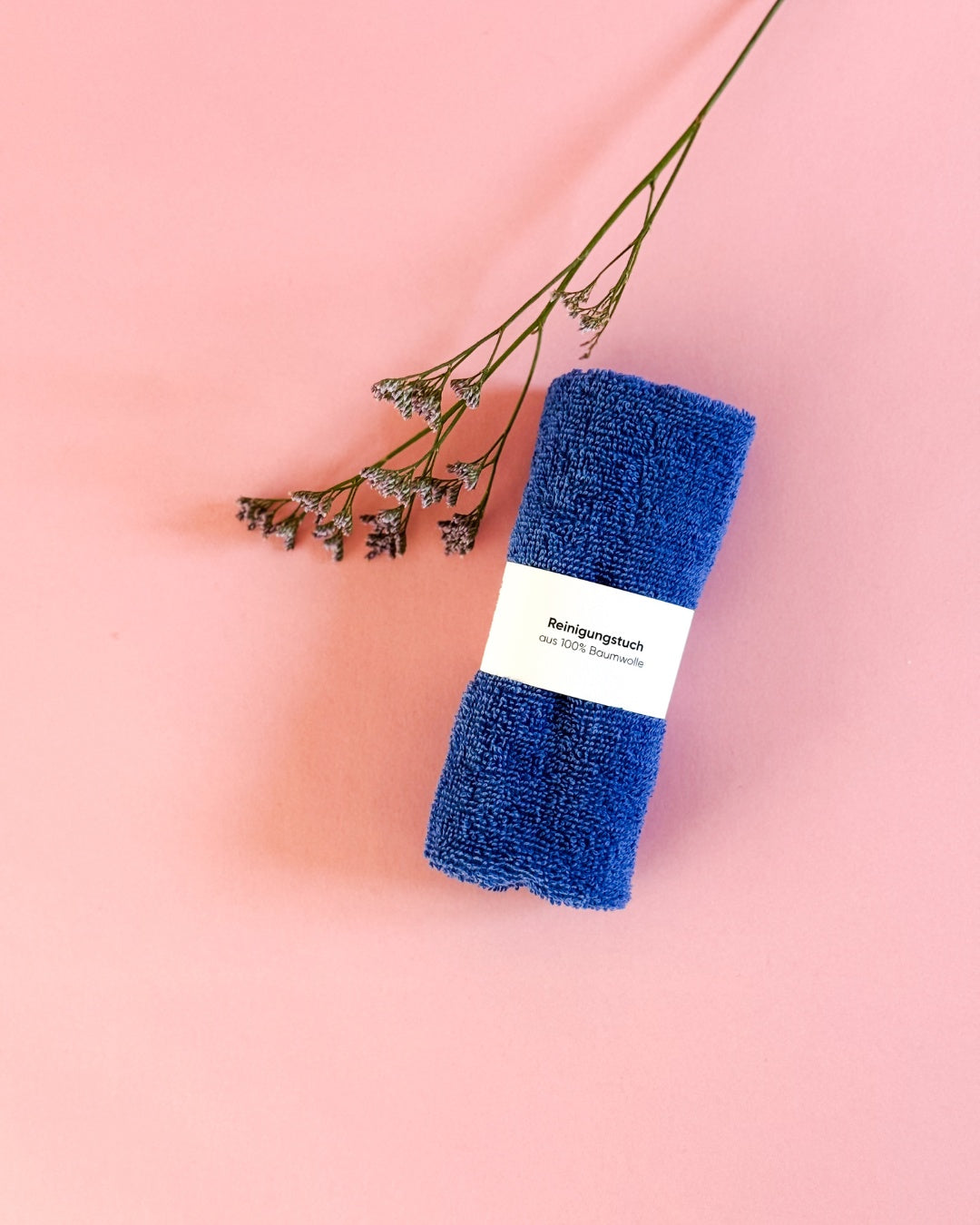 Blaues Reinigungstuch aus 100% Baumwolle, Ökotex-zertifiziert, mit Deko-Blume dekoriert.