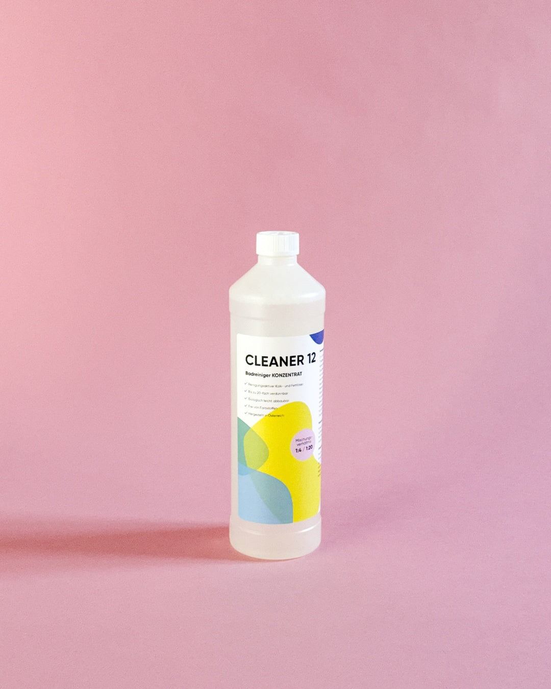 bazuba Cleaner 12 Badreiniger Konzentrat 1 Liter Flasche gegen Kalk vor rosa Hintergrund.