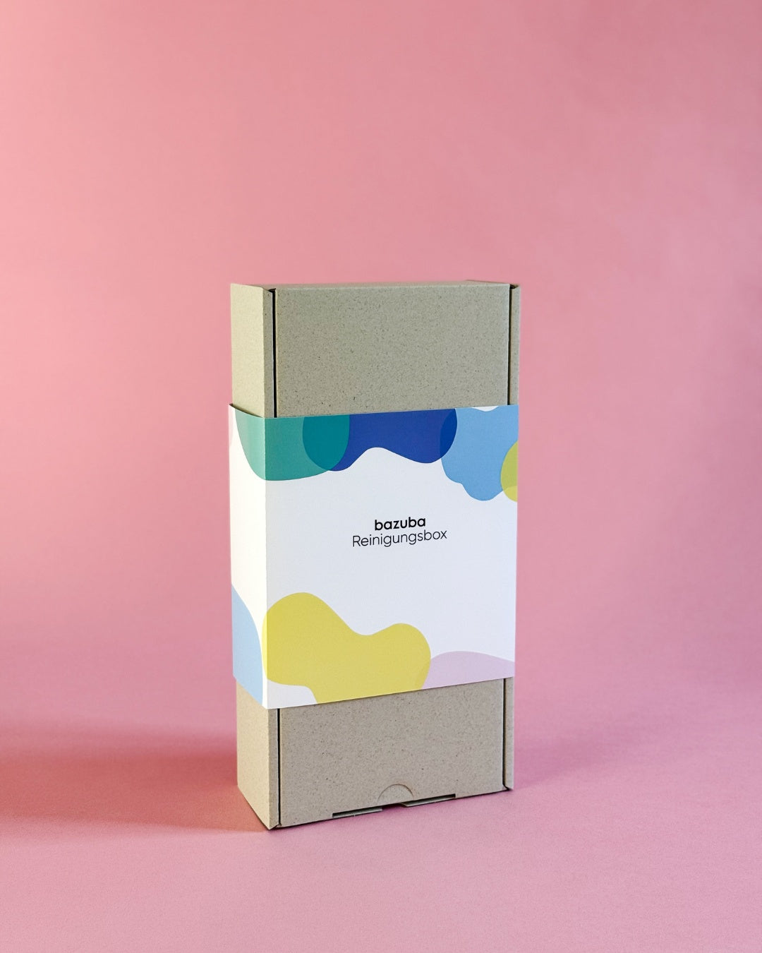 Geschlossene bazuba Reinigungsbox des Cleaner 12 Starterpakets vor rosa Hintergrund.