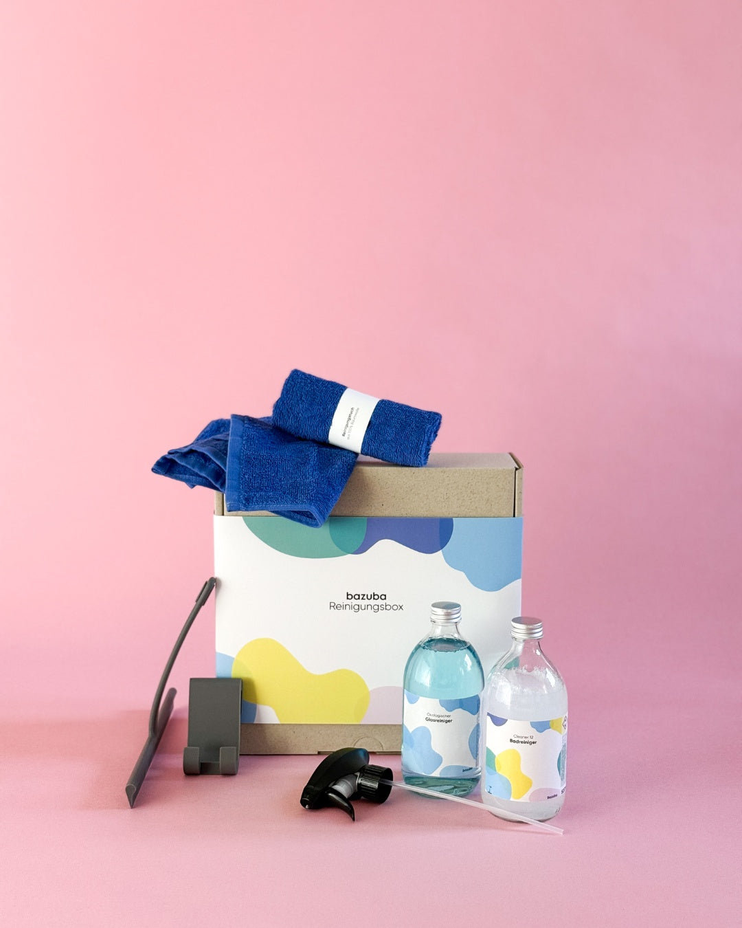 Geschlossene bazuba Box mit blauen Tüchern, Duschabzieher und zwei Glas-Sprühflaschen (Glasreiniger & Cleaner 12).