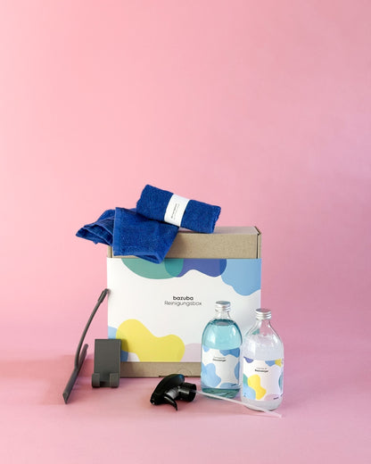 Geschlossene bazuba Box mit blauen Tüchern, Duschabzieher und zwei Glas-Sprühflaschen (Glasreiniger & Cleaner 12).