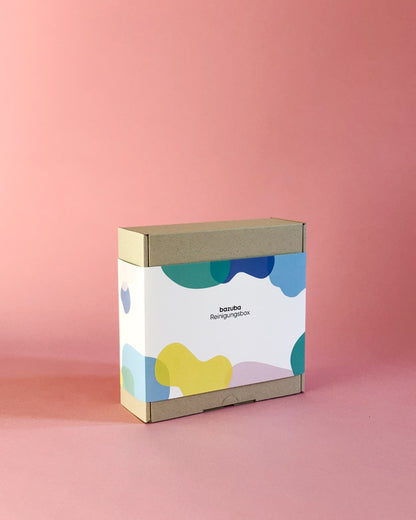 Die bazuba Reinigungsbox einzeln präsentiert vor einem modernen rosa Hintergrund.