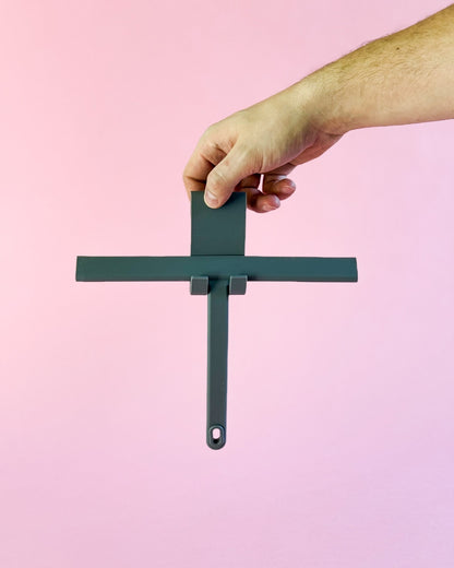 Grauer Silikon-Duschabzieher mit Haken, von einer Hand gehalten.